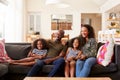 Family Sitting On Sofa At Home And Watching Movie On TV Together Royalty Free Stock Photo