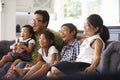 Family Sitting On Sofa At Home Watching TV Together Royalty Free Stock Photo