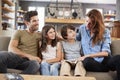 Family Sitting On Sofa In Lounge Reading Book Together Royalty Free Stock Photo