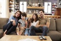 Family Sitting On Sofa In Open Plan Lounge Watching Television Royalty Free Stock Photo