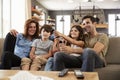 Family Sitting On Sofa In Open Plan Lounge Watching Television Royalty Free Stock Photo