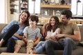 Family Sitting On Sofa In Open Plan Lounge Watching Television Royalty Free Stock Photo