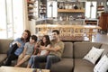 Family Sitting On Sofa In Open Plan Lounge Watching Television Royalty Free Stock Photo