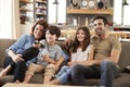 Family Sitting On Sofa In Open Plan Lounge Watching Television Royalty Free Stock Photo