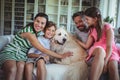 Family sitting on sofa with pet dog in living room Royalty Free Stock Photo