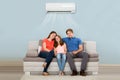 Family Sitting On Sofa Under Air Conditioning Royalty Free Stock Photo