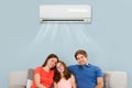 Family Sitting On Sofa Under Air Conditioning Royalty Free Stock Photo