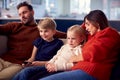 Family Sitting On Sofa Watching TV Together As Parents Fall Asleep Royalty Free Stock Photo