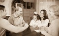 Family sitting at table with cards Royalty Free Stock Photo