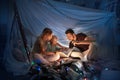 Family sitting in a teepee, reading stories with the flashlight Royalty Free Stock Photo