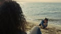 Family sitting together beach. Playful child building sand castle at sea shore.