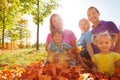 Family sitting together on leaves in the park Royalty Free Stock Photo