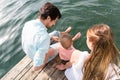 Family sitting on water hanging feet in the pond Royalty Free Stock Photo