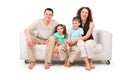 Family sitting on white leather sofa Royalty Free Stock Photo