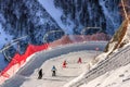 Family of skiers rides down snowy ski track on ski slopes of Gorky Gorod mountain ski resort on sunny winter day