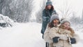 family sledding in winter. outdoor winter activity. Happy, laughing family, woman with 2 daughters are enjoying of Royalty Free Stock Photo