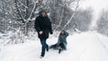 family sledding in winter. outdoor winter activity. Happy, laughing, playful married couple is enjoying of sledging on Royalty Free Stock Photo