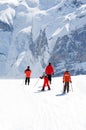 Family on slope. Rocky mountains in background.