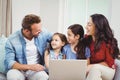 Family smiling and using laptop on sofa Royalty Free Stock Photo