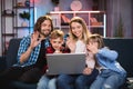 Family smiling and waving during video chat on laptop Royalty Free Stock Photo