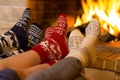 Family in socks near fireplace in winter or christmas time