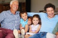 Family is something to be treasured. two children sitting with their father and grandfather indoors. Royalty Free Stock Photo