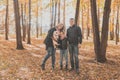 Family spend time in autumn park with a dog. Father, mother and daughter and jack russell terrier dog having fun in fall Royalty Free Stock Photo