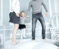 Happy family jumping on bed and having fun together. Royalty Free Stock Photo