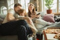 Family spending nice time together at home, looks happy and cheerful, eating pizza