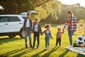 Family spending time together. Mother with four kids standing and holding hands against white suv car Royalty Free Stock Photo