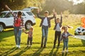 Family spending time together. Mother with four kids standing and holding hands against white suv car Royalty Free Stock Photo