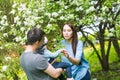 Family spending time together in the park in spring time. Mother, toddler and father playing in blooming garden.