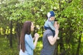 Family spending time together in the park in spring time. Mother, toddler and father playing in blooming garden. Royalty Free Stock Photo