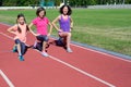 Family sport and fitness, happy mother and kids exercising and running on stadium track outdoors, active children Royalty Free Stock Photo