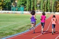 Family sport and fitness, happy mother and kids running on stadium track outdoors, children healthy active lifestyle Royalty Free Stock Photo