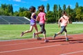 Family sport and fitness, happy mother and kids running on stadium track outdoors, children healthy lifestyle concept Royalty Free Stock Photo