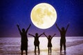 Family standing on beach and watching the moon.Celebrate Mid autumn festival