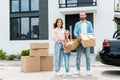 Family standing with boxes while moving into modern house