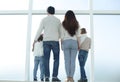 Family standing looking out the big window at copy space Royalty Free Stock Photo