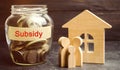 The family is standing near a glass jar with the inscription Subsidy. Financial aid, support to the population. Cash grants, Royalty Free Stock Photo