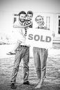 Family standing outside home with sold sign Royalty Free Stock Photo