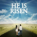 Family standing on the road with text he is risen Royalty Free Stock Photo