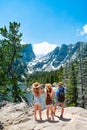 Family standing on top of the mountain looking at beautiful view.