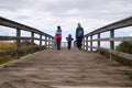 Family strolling along a wooden walkway