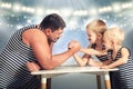 Family of strongman. The father of two sons in vintage costume of athletes compete in arm wrestling. Family look. Royalty Free Stock Photo