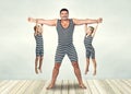 Family of strongman. The father of two sons in vintage costume of athletes perform strength exercises. Family look. Royalty Free Stock Photo