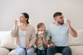 Family suffering from runny nose on sofa at home