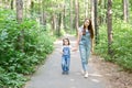 Family, summer and nature concept - Attractive young woman and beautiful little daughter girl walking in green park Royalty Free Stock Photo