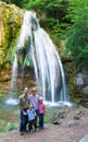 Family on summer waterfall background