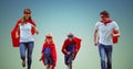 Family in superhero costume running together against sky blue background Royalty Free Stock Photo